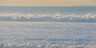 在一个阳光明媚的晚上，海浪在海岸附近撞击