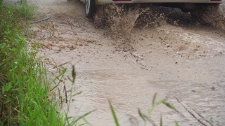 汽车穿过泥泞的水坑视频素材模板下载