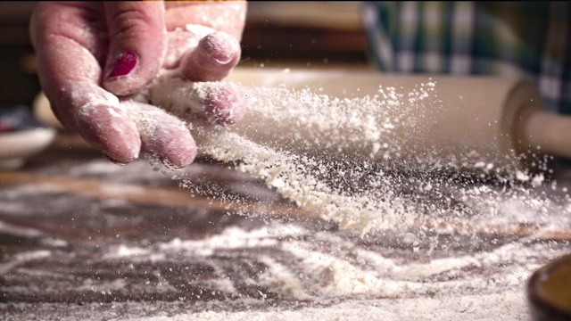 女人的手在披萨面团上撒面粉的超级慢动作视频，1000帧/秒