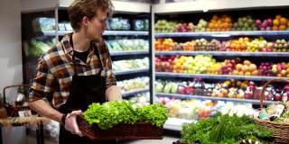 超市的有机蔬菜沙拉吧。在当地超市的酒吧里，一名男店员正在整理新鲜的蔬菜。慢动作