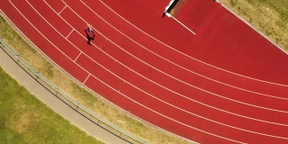 中年女性运动员在跑道上奔跑的鸟瞰图