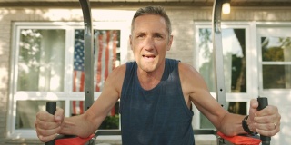 一个成熟的男人在后院的健身房锻炼