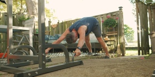 一个成熟的男人在后院的健身房锻炼