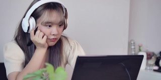 一名亚洲少女在学习休息和新冠肺炎隔离期间在客厅听音乐、看电影、和朋友聊天