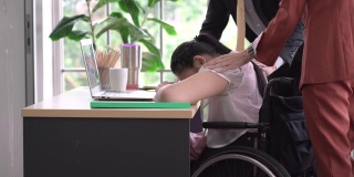 同事们在安慰坐在轮椅上的悲伤女人