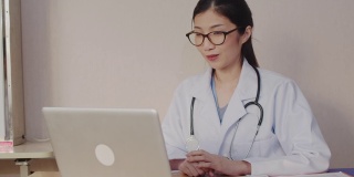 亚洲女医生通过视频聊天在线咨询病人，远程保健和远程医疗的概念