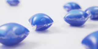 蓝色洗衣粉落在白色背景上的豆荚的特写。