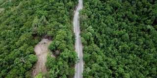 公路的鸟瞰图穿过绿色的森林在泰国清莱省的高地山脉。