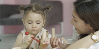 妈妈教小女孩玩玩具，家庭教育的概念