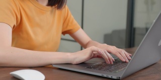 在笔记本电脑上工作的女性，在长时间的电脑工作后手腕关节疼痛和不适。