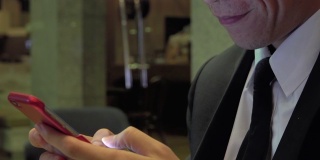 亚洲商人在咖啡馆玩智能手机