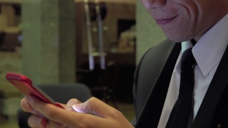 亚洲商人在咖啡馆玩智能手机视频素材模板下载