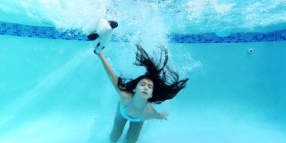 小女孩戴着动物面具在游泳池里跳