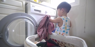 亚洲男婴装衣服在家里的自动洗衣机洗衣服