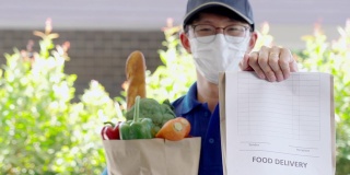 4K视频视频在线杂货购物食品配送服务，年轻的亚洲人在蓝色制服送水果和蔬菜到接收客户的前台