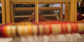 时尚潮流。工艺背景。在老式织机上织造的过程。细部的传统编织手工织机与羊毛近。工艺背景。传统的古老的织机