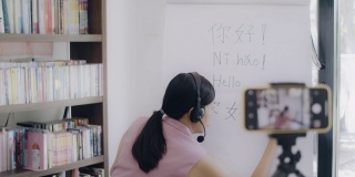 亚洲女教师远程教学在家办公与在线技术设备。为在家学习的学生教授汉语。新常态的生活方式概念，在家工作。