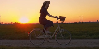 日落时在田野间骑自行车的人