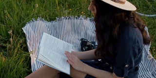 SLO MO MS年轻女人在野餐毯子上看书