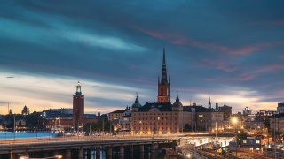 斯德哥尔摩,瑞典。夏日夜晚的斯德哥尔摩天际线风景。著名的热门目的地景区在日落灯光。里达霍尔姆教堂，地铁。白天到夜晚的过渡时间流逝视频素材模板下载