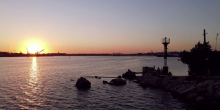 日落时飞过海港。港