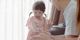 亚洲父母教他们的小女儿如何洗手。