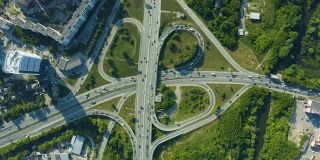 鸟瞰图的一个复杂的高速公路交叉口与交通移动。从上面可以看到汽车、卡车、货车和火车在繁忙的道路交汇处穿梭
