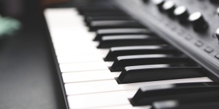 黑白琴键上的模拟合成器装置，用于电子音乐制作人在录音棚中录制缩小视频剪辑。