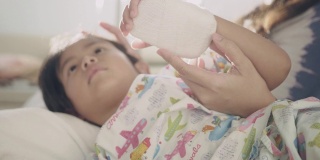 一个亚洲小男孩躺在医院的病床上。