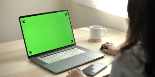 一个女人使用绿色模拟屏幕笔记本电脑的特写