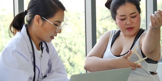 亚洲医生用听诊器和测量卡尺测量并建议大块头女性