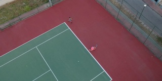一个男孩和一个女孩正在打网球高清视频与平移无人机视图