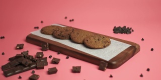 在一块木板上摆放4K格式的巧克力曲奇。准备吃新鲜饼干的概念。