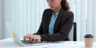 女商人在办公室用笔记本电脑制作投资营销计划和财务会计数据的4K视频