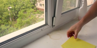一个男人用一块破布擦窗台。清洁阳台。