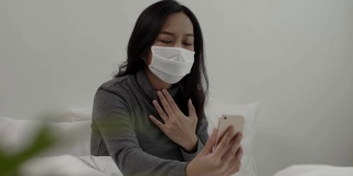 生病的年轻亚洲女子在线视频通话通过智能手机与医生交谈。