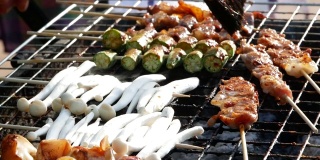 云南式烧烤:肉、鱿鱼、蘑菇和猪肉在木炭烤架上烧烤，配以海鲜酱或中国辣药草食用。当地市场上的泰国美味街头小吃。