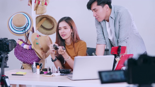 年轻的亚洲夫妇博客正在通过在线直播评论化妆品。