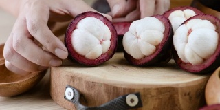 手捏山竹，切成紫色皮和白色果肉的果后。