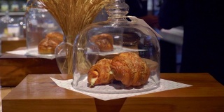 新鲜的法国牛角面包在糕点店与人的背景。新鲜的面包