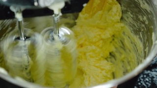 近距离观察搅拌机搅拌美味奶油制作蛋糕的过程。视频素材模板下载