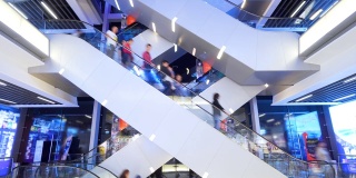 时光流逝自动扶梯在现代购物中心的人群中。非常繁忙，挤满了客户。