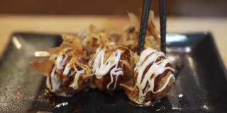 用筷子挑章鱼烧，一种球形的日本小吃