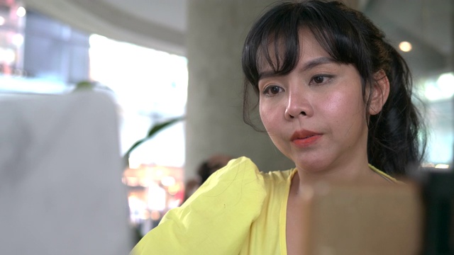 微笑年轻的泰国少数民族商业女性影响者在智能手机上录制视频博客播客