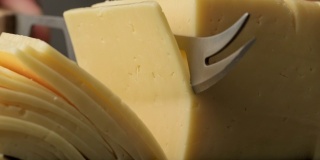 用刀切奶酪做早餐。切奶酪用的锋利刀。