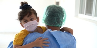 男医护人员在疫情期间从医院回家后拥抱他的女儿