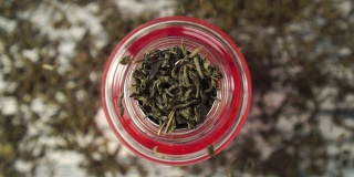 近距离观察，干绿茶叶子落入茶壶的滤网中