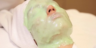 一位年轻女子在脸上敷了一层绿藻年轻化面膜