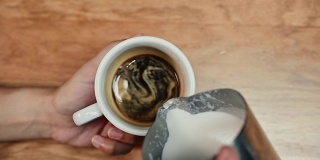 一个咖啡师展示的艺术倒和准备一杯咖啡的特写视图。拿铁艺术。高质量的全高清镜头。