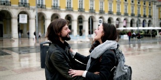 一对快乐的年轻夫妇在城市广场相遇